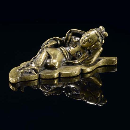 A BRONZE SCROLL WEIGHT OF A RECLINING LADY